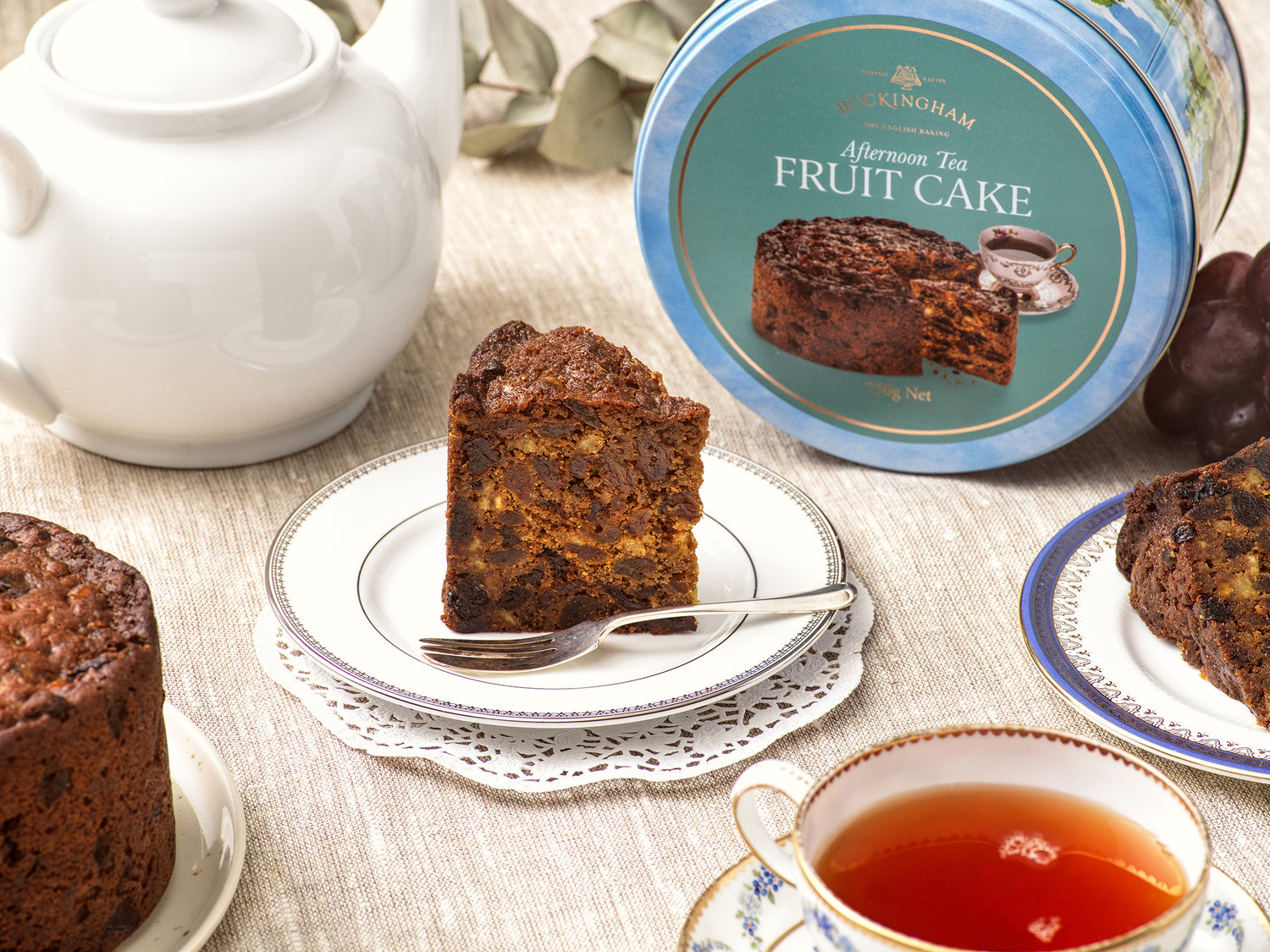 English Afternoon Tea fruit cake in gift tin with slice of fruit cake on plate