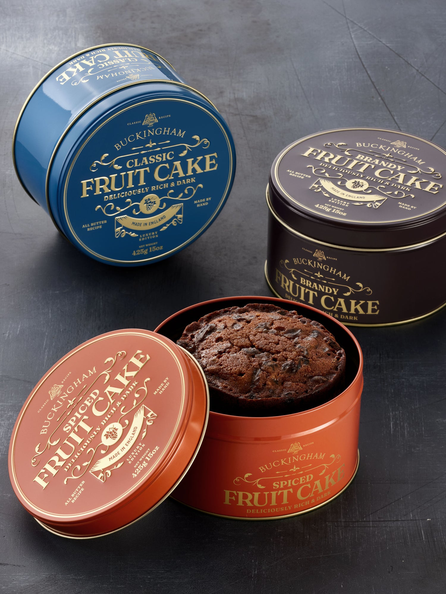 Three flavours of English fruit cake in embossed gift tins